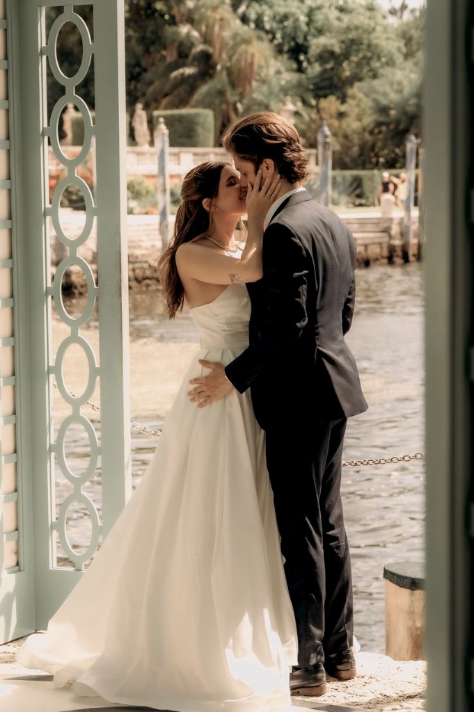 Bride and groom sharing a kiss on a waterfront pier