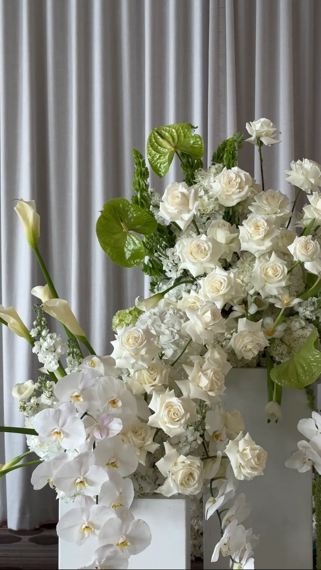 White roses, orchids and green anthurium in a ceremony arrangement