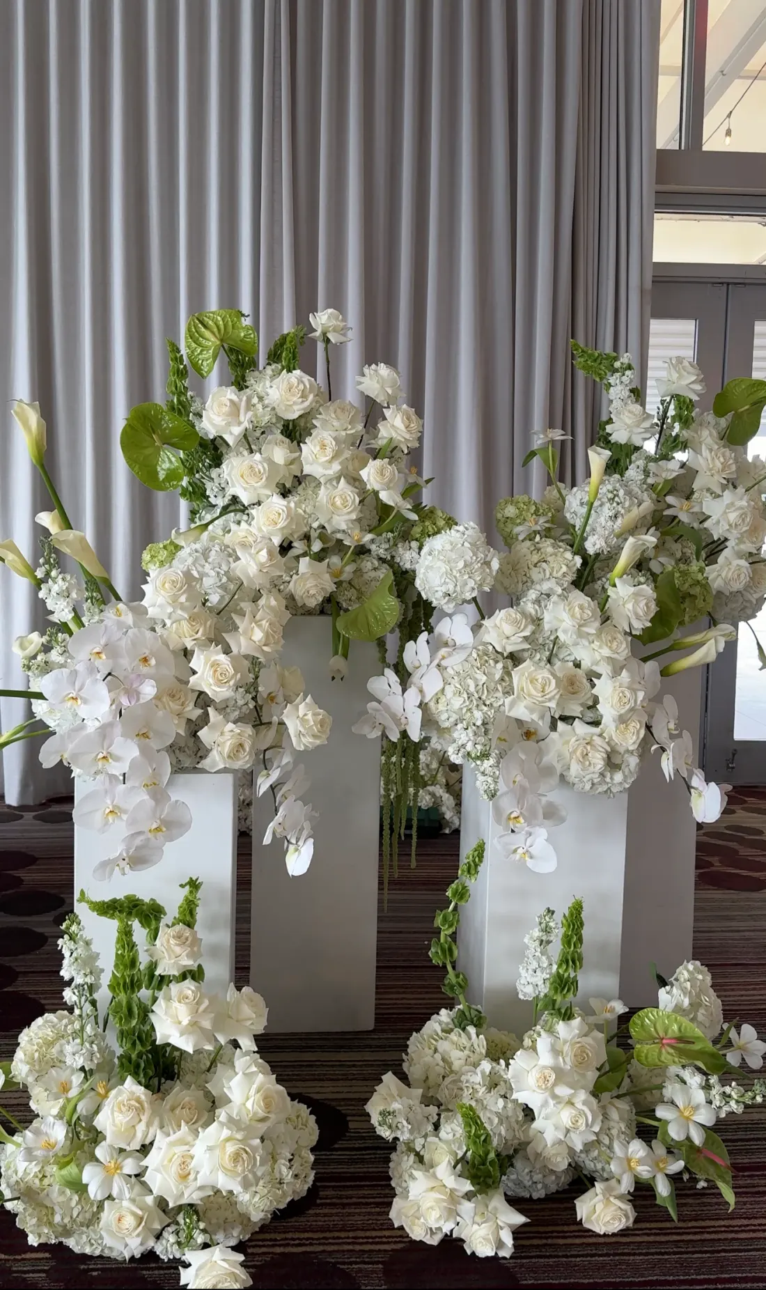 Sculptural white floral installation on ivory pedestals