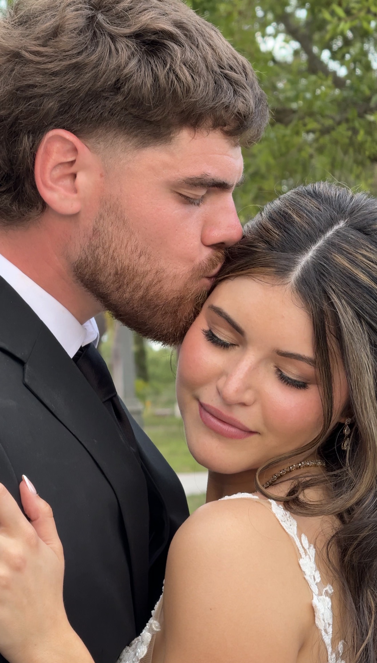 Groom kissing bride's forehead in a close intimate moment